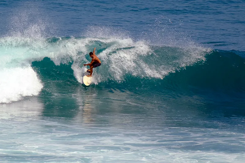 Surfer auf einer großen Welle in Uluwatu Bali.